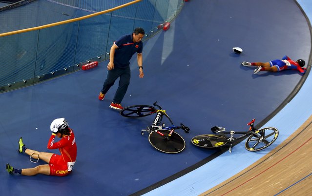 Cycling, UCI World Track Cycling Championships, London, Britain on March 5, 2016: An official rushes to move bicycles as Luo Xiao Ling of China (L) and Marlies Mejias Garcia of Cuba lie on the track after crashing in the women's omnium elimination race. (Photo by Andrew Winning/Reuters)