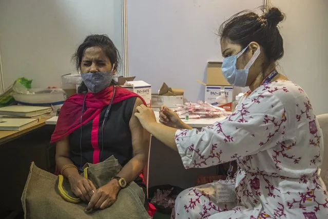 A woman receives Covishield COVID-19 vaccine at a vaccination center in Mumbai, India, Thursday, September 23, 2021. (Photo by Rafiq Maqbool/AP Photo)
