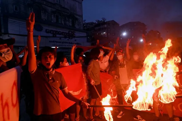 Protesters burn Myanmar flags during a demonstration against the military coup in Yangon, Myanmar on July 29, 2021. (Photo by AFP Photo/Stringer)
