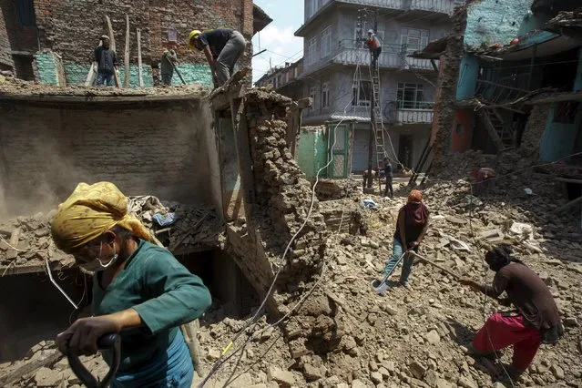 Local residents clear the debris of their collapsed houses after the earthquake at Harisiddhi village, on the outskirts of Kathmandu, Nepal, May 6, 2015. (Photo by Athit Perawongmetha/Reuters)