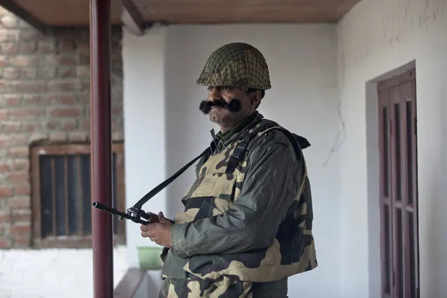 An Indian paramilitary soldier stands guard at a polling station during the second phase of India's general elections, in Srinagar, Indian controlled Kashmir, Thursday, April 18, 2019. Kashmiri separatist leaders who challenge India's sovereignty over the disputed region have called for a boycott of the vote. Most polling stations in Srinagar and Budgam areas of Kashmir looked deserted in the morning with more armed police, paramilitary soldiers and election staff present than voters. (Photo by Dar Yasin/AP Photo)