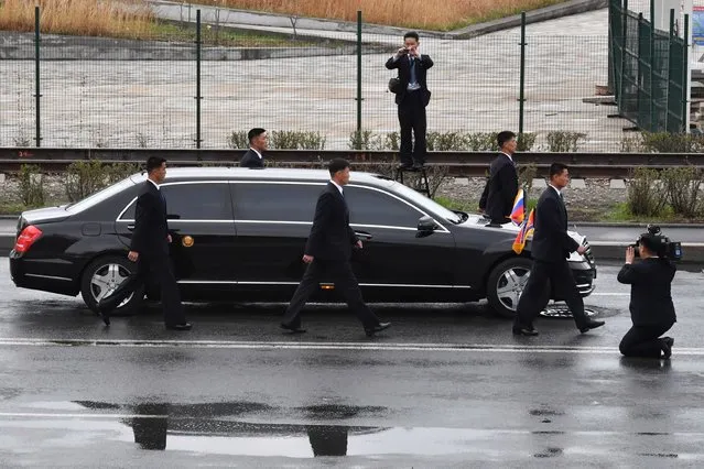 Bodyguards surround the car of North Korean leader Kim Jong Un as it drives away after a wreath-laying ceremony at a WWII memorial in the far-eastern Russian port of Vladivostok on April 26, 2019. (Photo by Yuri Kadobnov/AFP Photo)