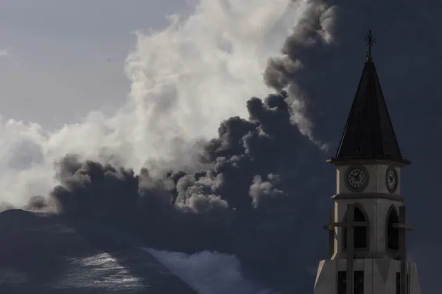 The Cumbre Vieja volcano continues to erupt above a church spire in the town of El Paso on November 12, 2021 in La Palma, Spain. The volcano has been erupting since September 19, 2021 after weeks of seismic activity, resulting in millions of Euros worth of damage to properties and businesses, as the lava flowed down the mountainside towards the sea. (Photo by Dan Kitwood/Getty Images)