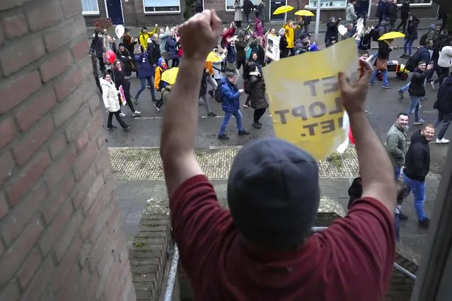A resident clenches ahis fist while holding a sign reading “It's Not Right” as thousand of demonstrators march in Utrecht, Netherlands, Saturday, December 4, 2021, to protest against COVID-19 restrictions and the lockdown. (Photo by Peter Dejong/AP Photo)
