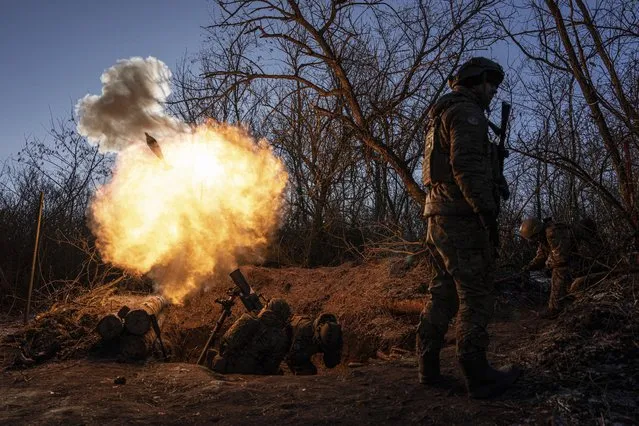 Ukrainian servicemen fire a 120mm mortar towards Russian positions at the frontline near Bakhmut, Donetsk region, Ukraine, Wednesday, January 11, 2023. (Photo by Evgeniy Maloletka/AP Photo)