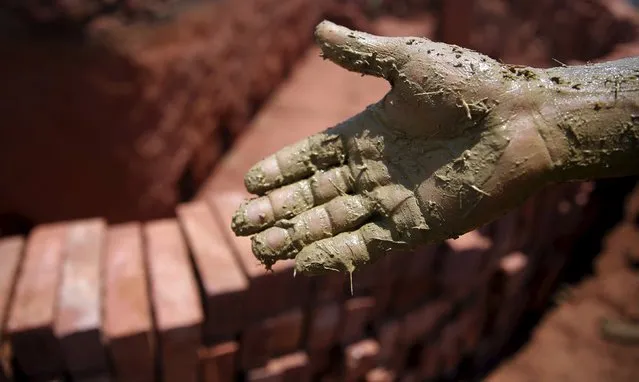 A labourer shows his hand after preparing soil to make bricks at a traditional brick factory in Arab Mesad district of Helwan, northeast of Cairo, May 14, 2015. (Photo by Amr Abdallah Dalsh/Reuters)