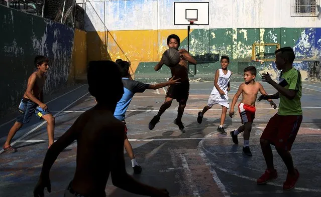 A group of boys play basketball at the Petare shantytown, in Caracas, Venezuela, Thursday, May 16, 2019. (Photo by Martin Mejia/AP Photo)