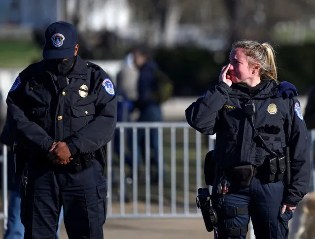 US Capital police react after the casket with fallen police officer, Brian Sicknick, passed during a funeral procession in Washington, DC on January 10, 2021. US Capitol Police officer Sicknick was reportedly struck in the head with a fire extinguisher on Wednesday while struggling with the rioters who swarmed through the halls of Congress and passed from his injuries. Donald Trump faced fresh calls Sunday from some members of his own party to resign over the violent incursion into the US Capitol, as the threat builds for a historic second impeachment effort in his final 10 days in the White House. (Photo by Andrew Caballero-Reynolds/AFP Photo)