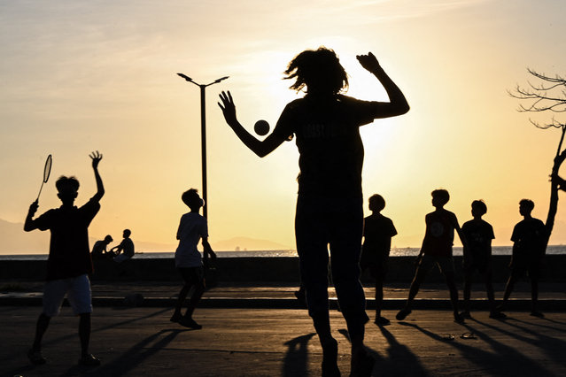 Students play volleyball along a street in Manila on April 5, 2024. Thousands of schools in the Philippines suspended in-person classes on April 5, the education department said, as parts of the tropical country endured dangerously high temperatures. (Photo by Jam Sta Rosa/AFP Photo)