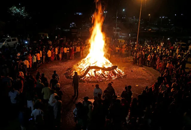 Hindu devotees walk around a bonfire during a ritual known as “Holika Dahan” which is part of Holi, festival of colours, celebrations in Ahmedabad, India March 12, 2017. (Photo by Amit Dave/Reuters)