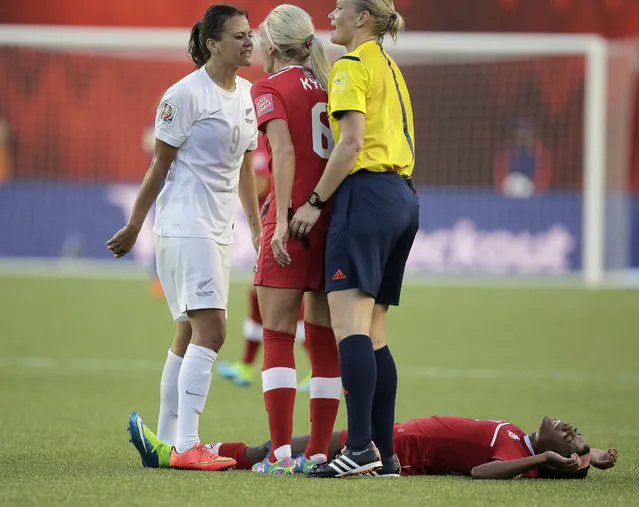 Canada defender Kadeisha Buchanan (3) lies on the field as midfielder Kaylyn Kyle (6) argues with New Zealand forward Amber Hearn (9) in Edmonton, June 11, 2015. (Photo by Erich Schlegel/USA TODAY Sports)