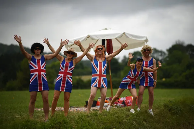Cycling enthusiasts wearing dresses with the Union Jack gesture on the roadside as they wait for riders during the fifteen stage of the 106th edition of the Tour de France cycling race between Limoux and Foix Prat d'Albis, in Foix Prat d'Albis on July 21, 2019. (Photo by Anne-Christine Poujoulat/AFP Photo)