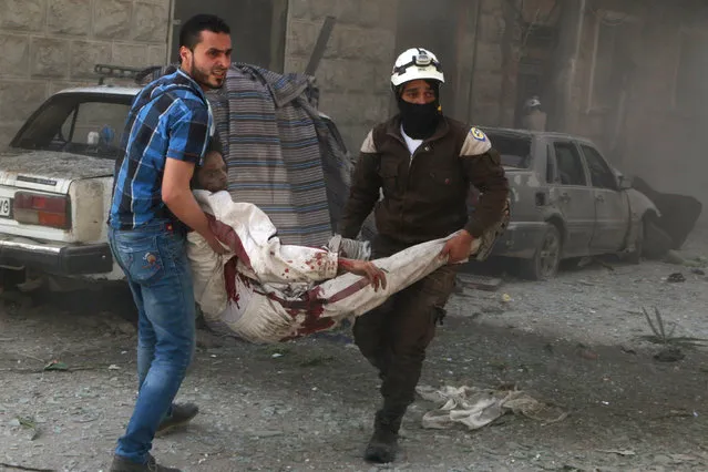 Civil defense members carry an injured civilian at a site hit by airstrikes in the rebel held area of Aleppo's al-Fardous district, Syria, April 29, 2016. (Photo by Abdalrhman Ismail/Reuters)