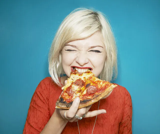 Woman eating pizza slice. (Photo by Tara Moore/Getty Images)