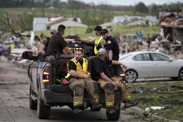 Law enforcement officers and firefighters ride in a truck past homes destroyed by a tornado Tuesday, May 21, 2024, in Greenfield, Iowa. (Photo by Charlie Neibergall)/AP Photo