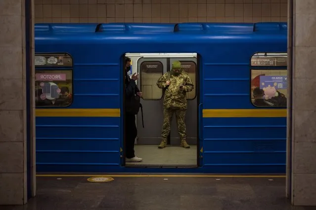 A Ukrainian army officer looks at his phone in a local train in Kyiv, Ukraine, Wednesday, February 23, 2022. Ukraine urged its citizens to leave Russia as Europe braced for further confrontation Wednesday after Russia's leader received authorization to use military force outside his country and the West responded with a raft of sanctions. (Photo by Emilio Morenatti/AP Photo)