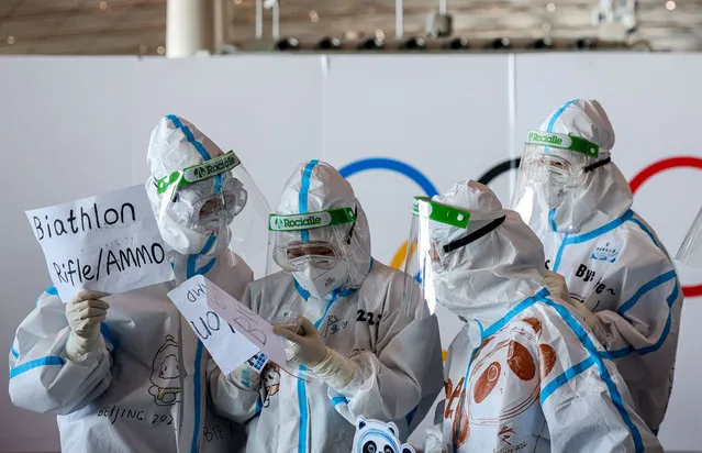Airport staff in hazmat suits work at the Beijing Capital International Airport on February 21, 2022 in Beijing, China. Officials, athletes, and media have started to leave Beijing after the closing ceremony of the Beijing 2022 Winter Olympics. (Photo by Annice Lyn/Getty Images)