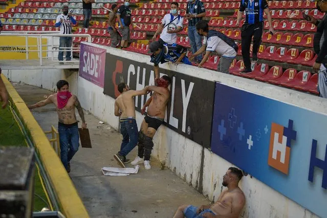Fans clash during a Mexican soccer league match between the host Queretaro and Atlas from Guadalajara, at the Corregidora stadium, in Queretaro, Mexico, Saturday, March 5, 2022. (Photo by Sergio Gonzalez/AP Photo)
