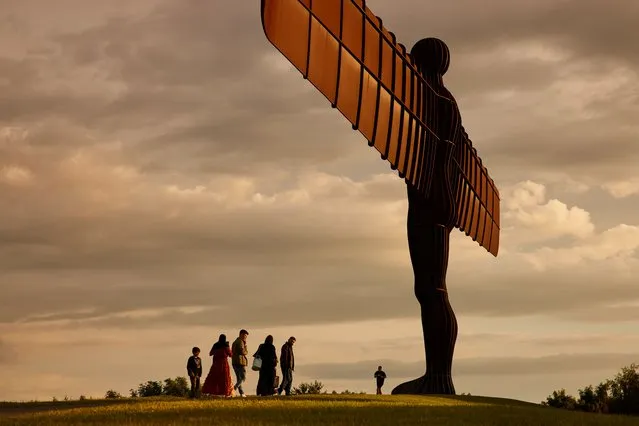 Visitors walk by the Angel of the North statue in Gateshead, United Kingdom in July 2021, looking out over the north-east region, which is currently the area in England worst affected by coronavirus. (Photo by Christopher Thomond/The Guardian)