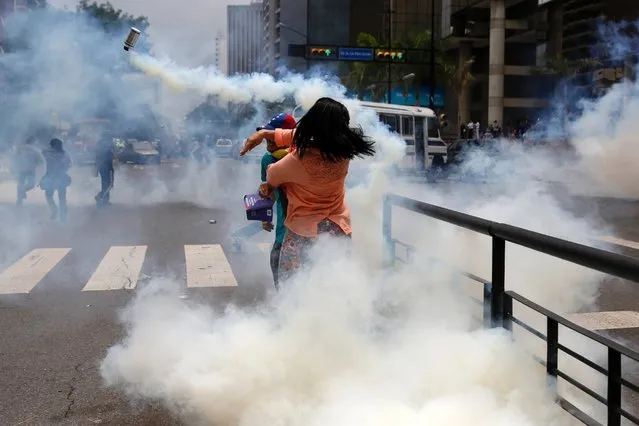 An anti-government protester throws a gas canister back at the police during a protest against President Nicolas Maduro's government in Caracas, May 8, 2014. Venezuelan authorities arrested hundreds of youth activists who had spent weeks in camps set up in public spaces as part of protests. (Photo by Carlos Garcia Rawlins/Reuters)