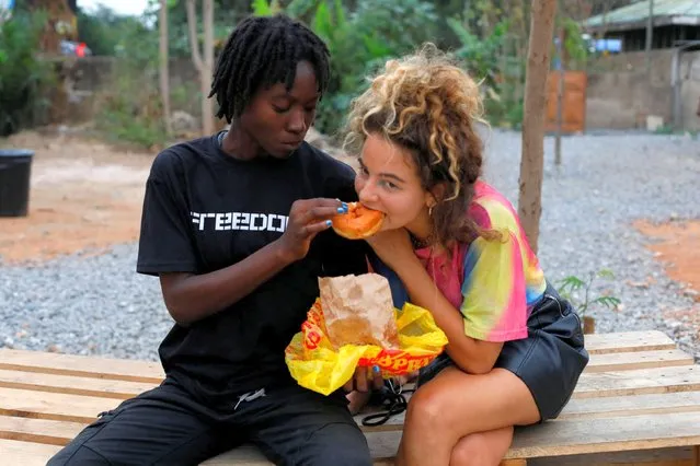 Harmonie Bataka, 27, a skateboarder and skateboarding tutor, shares a snack with a colleague, at the Freedom Skatepark in Accra, Ghana, February 17, 2022. Every Thursday the park is open exclusively to women and girls, who can use the equipment and take lessons for free. (Photo by Francis Kokoroko/Reuters)