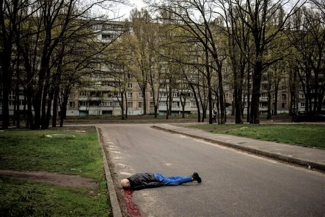 The body of a man lies on the street in Kharkiv, Ukraine on April 19, 2022. (Photo by Alkis Konstantinidis/Reuters)