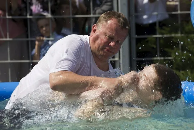 A Jehovah's Witness is baptized in a pool during a regional congress of Jehovah's Witnesses at Traktar Stadium in Minsk, Belarus, July 25, 2015. (Photo by Vasily Fedosenko/Reuters)