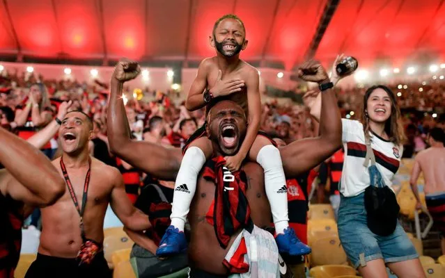 Flamengo soccer fans cheer a goal scored by Gabriel against Argentina's River Plate in the Copa Libertadores final match, broadcast on a giant screen at a watch party at the Macarena Stadium, in Rio de Janeiro, Brazil, Saturday, November 23, 2019. The first single-match final will be played in front of more than 65,000 fans at Lima’s Monumental Stadium. The match was originally scheduled for Santiago’s National Stadium, but it was moved because of street protests in Chile. (Photo by Silvia Izquierdo/AP Photo)