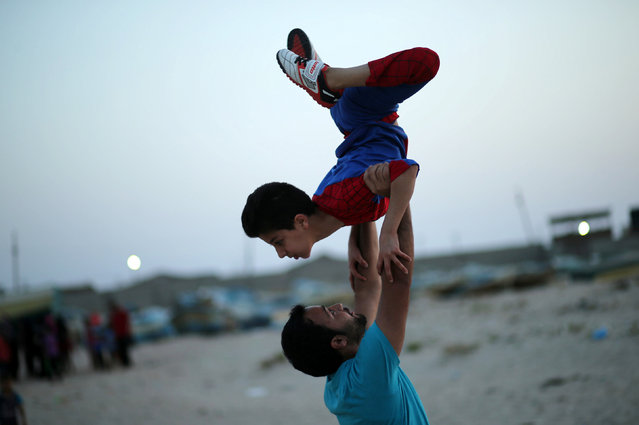 Mohamad al-Sheikh, 12, demonstrates acrobatics skills on a beach in Gaza City June 2, 2016. (Photo by Mohammed Salem/Reuters)