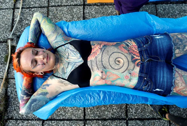 Kaitlin, 28, from the United States waits to be suspended by the professional body artist Dino Helvida in Zagreb, Croatia June 7, 2016. (Photo by Antonio Bronic/Reuters)