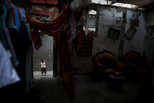 A Palestinian boy stands outside his family's house during power cut at Shatti (beach) refugee camp in Gaza City July 23, 2015. (Photo by Mohammed Salem/Reuters)