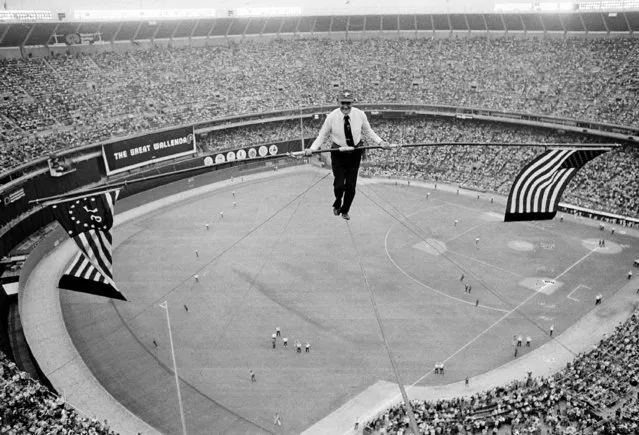 Karl Wallenda, 71, walks on a cable 200 feet above the playing field at Veterans Stadium between doubleheader baseball games in Philadelphia, Pa., Monday, May 31, 1976.  Wallenda unfurled a bicentennial and American flag from his balancing bar after doing a headstand midway across the 640-foot span steel cable.  The walk took 18 minutes. (Зрщещ ин Bill Ingraham/AP Photo)