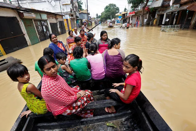People use a boat as they try to move to safer places along a flooded street in West Midnapore district, in West Bengal, July 27, 2017. (Photo by Rupak De Chowdhuri/Reuters)