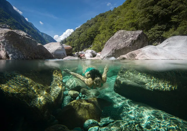 A young woman dives in the Verzasca river in the Valle Verzasca, Ticino canton, Switzerland, 15 August 2017 (issued 16 August 2017). Numerous people enjoyed the warm weather and refreshing temperatures of the Verzasca river's waters on this mid-August summer day. (Photo by Pablo Gianinazzi/EPA)