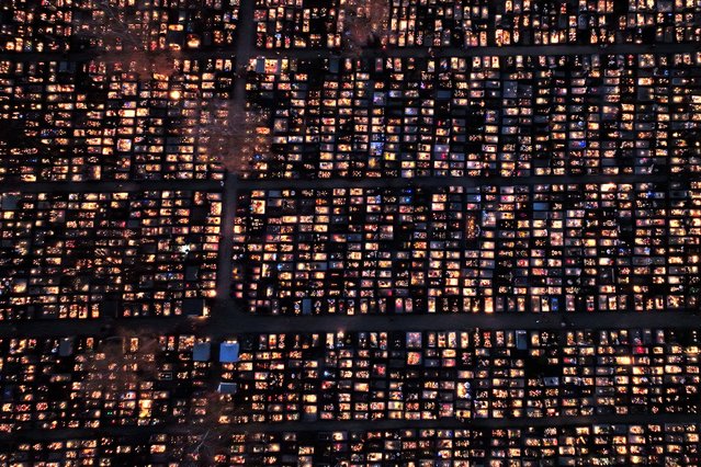 This aerial photograph taken on November 1, 2024 shows a cemetery illuminated with candles during All Saints' Day, a holiday to remember deceased loved ones, in Kielce. Traditionally, on the first day of November, millions of Poles head to family graves in their ancestors' hometowns, and some cross the entire country to pay their respects. (Photo by Sergei Gapon/AFP Photo)