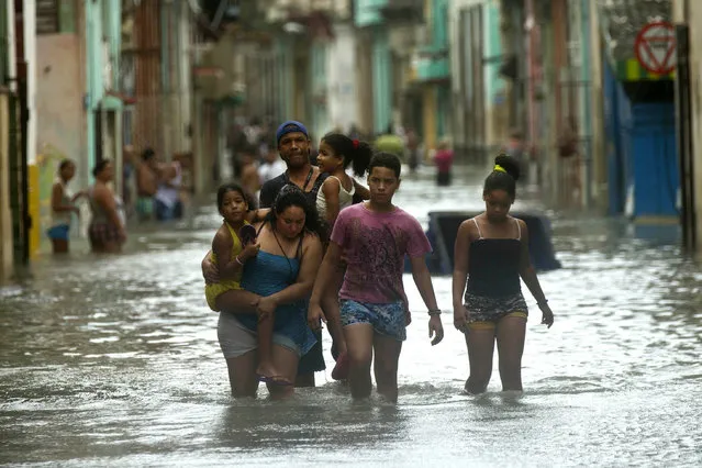 People walk through flooded streets in Havana after the passage of Hurricane Irma in Cuba, Sunday, September 10, 2017. (Photo by Ramon Espinosa/AP Photo)