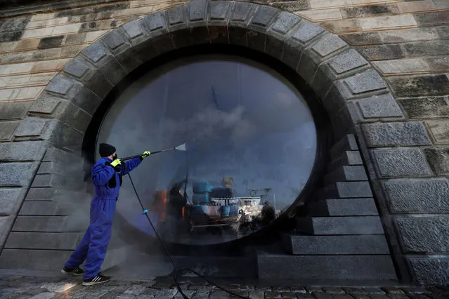 A municipality worker in a protective suit sprays a disinfectant along the Vltava river to curb the spread of the coronavirus disease (COVID-19) in Prague, Czech Republic, April 1, 2020. (Photo by David W. Cerny/Reuters)