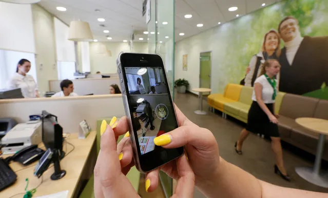 A woman plays the augmented reality mobile game “Pokemon Go” by Nintendo at a branch of Sberbank in central Krasnoyarsk, Siberia, Russia, July 20, 2016. (Photo by Ilya Naymushin/Reuters)