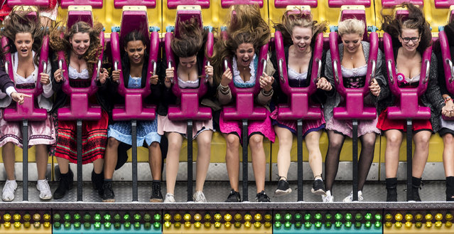 Visitors sit in a leisure ride at the fairground during the opening of the 184rd edition of the annual traditional Oktoberfest beer and amusement festival in the German Bavaria state's capital Munich, Germany, 16 September 2017. The Oktoberfest runs from 17 September to 03 October 2017 and is expected to attract once more several millions of visitors from all over the world. (Photo by Christian Bruna/EPA/EFE)