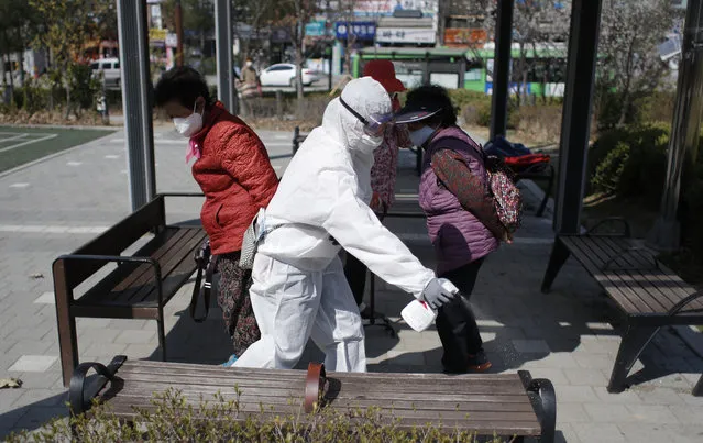 Members of a local residents group wear protective gear as they disinfect a local park as a precaution against the new coronavirus in Seoul, South Korea, Monday, March 23, 2020. (Photo by Lee Jin-man/AP Photo)