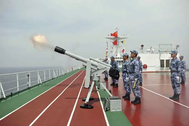 Chinese People's Liberation Army (PLA) Navy fires a salute during a commemoration ceremony for Chinese soldiers killed during the First Sino-Japanese War, near Liugong island in Weihai, Shandong province, August 27, 2014. The Chinese Navy is marking the 120th anniversary of the war, commonly known in China as the “War of Jia-wu”. (Photo by Reuters/Stringer)