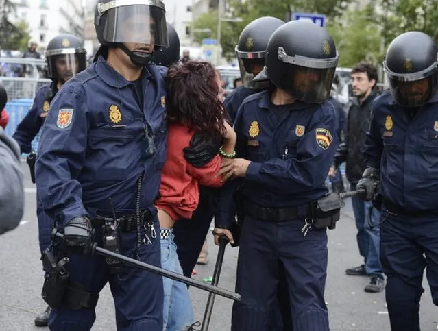 Riot policemen arrest a protester during a demonstration organized by Spain's "indignant" protesters to decry an economic crisis they say has "kidnapped" democracy, on September 25, 2012 in Madrid. Spanish riot police fired rubber bullets and baton-charged protesters as thousands rallied near parliament in Madrid in anger at the government's handling of the economic crisis.AFP PHOTO/ PIERRE-PHILIPPE MARCOU        (Photo credit should read PIERRE-PHILIPPE MARCOU/AFP/GettyImages)