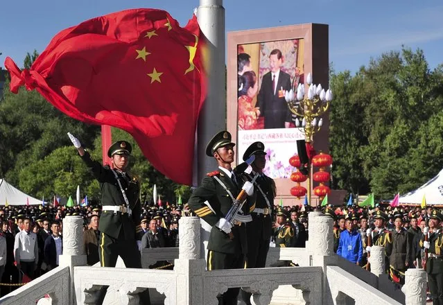 A paramilitary policeman unfurls a Chinese national flag during a flag raising ceremony at the celebrations event marking the 50th anniversary of the founding of the Tibet Autonomous Region, in Lhasa, Tibet Autonomous Region, China, September 8, 2015. (Photo by Reuters/China Daily)