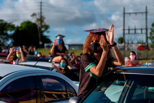 A graduating student from the Ramon Power Y Giralt High School celebrates while attending a symbolic graduation from her car to maintain social distance at a parking lot in Las Piedras, Puerto Rico, on May 13, 2020. The event was organized by the municipal government to congratulate the local graduates whose traditional ceremonies were canceled due to the coronavirus pandemic, with the condition of staying inside their vehicles. (Photo by Ricardo Arduengo/AFP Photo)