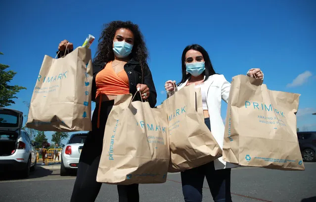 Shoppers carry goods bought at Primark at the Rushden Lakes shopping complex on June 15, 2020 in Rushden, United Kingdom. The British government have relaxed coronavirus lockdown laws significantly from Monday June 15, allowing zoos, safari parks and non-essential shops to open to visitors. Places of worship will allow individual prayers and protective facemasks become mandatory on London Transport. (Photo by David Rogers/Getty Images)