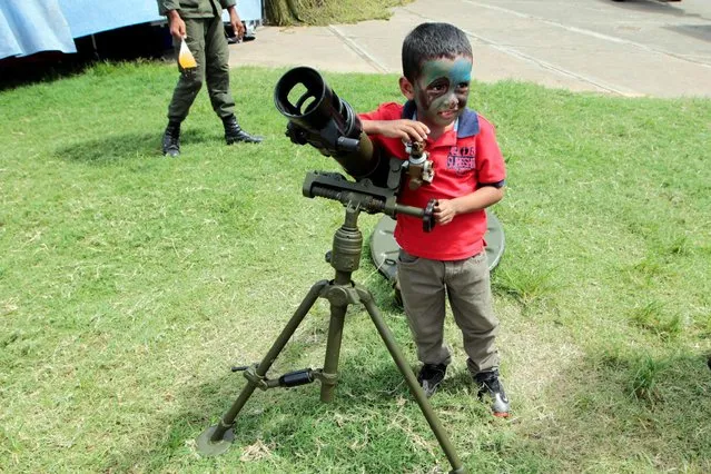 A child with his face painted stands next to a 82mm mortar during the Static Military Civic Exhibition in Managua, Nicaragua August 17, 2016. (Photo by Oswaldo Rivas/Reuters)
