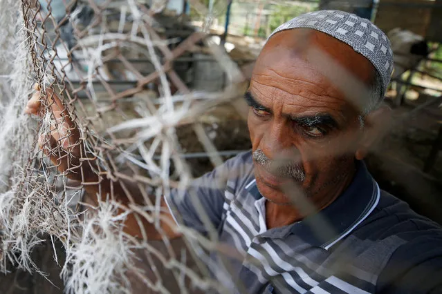 A Palestinian man stands by a fence at the site of an Israeli air strike in Gaza City on July 6, 2020. (Photo by Mohammed Salem/Reuters)