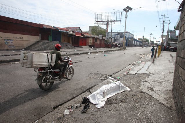 The covered body of a person killed amid gang violence in the Delmas 30 neighborhood lies on a street as police officers clash with gangs amid ongoing violence, in Port-au-Prince, Haiti, on February 26, 2025. (Photo by Fildor Pq Egeder/Reuters)