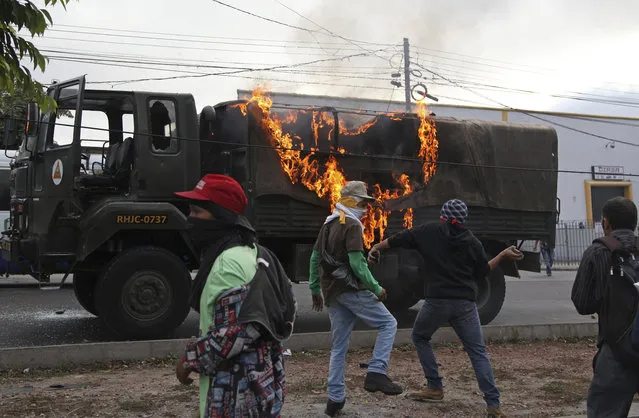 A military truck goes up in flames after it was set on fire by protesters, in Tegucigalpa, Honduras, Friday, December 15, 2017. Protests in support of Honduran presidential opposition candidate Salvador Nasralla continued throughout the country Friday as Nasralla demanded a full recount, refused to recognize the results and called for a nationwide protests. (Photo by Fernando Antonio/AP Photo)
