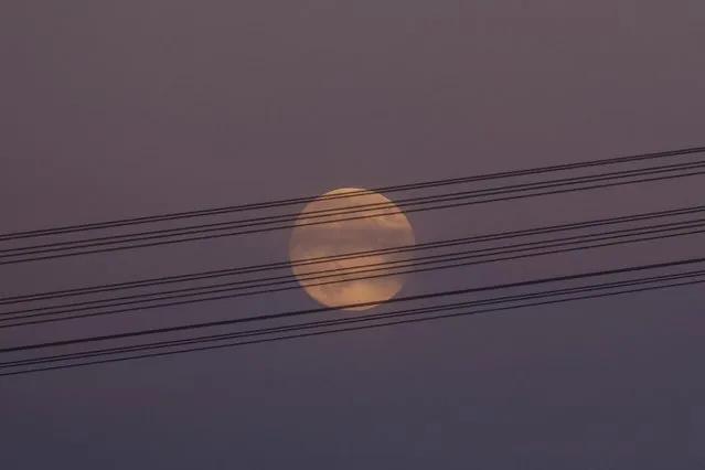 A full moon rises behind high-voltage power lines, amid Russia’s attack on Ukraine, in Dnipropetrovsk region, Ukraine on November 7, 2022. (Photo by Valentyn Ogirenko/Reuters)